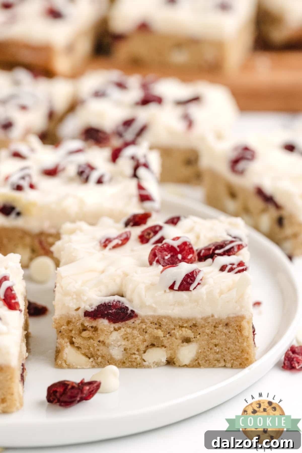 Thick and chewy cookie bar recipe with cream cheese frosting and white chocolate drizzle. 