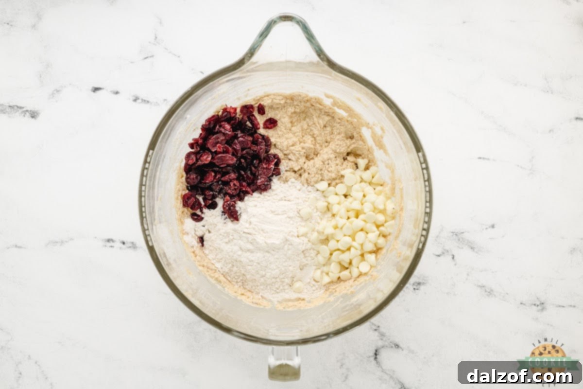 Add flour, white chocolate chips, and dried cranberries. 