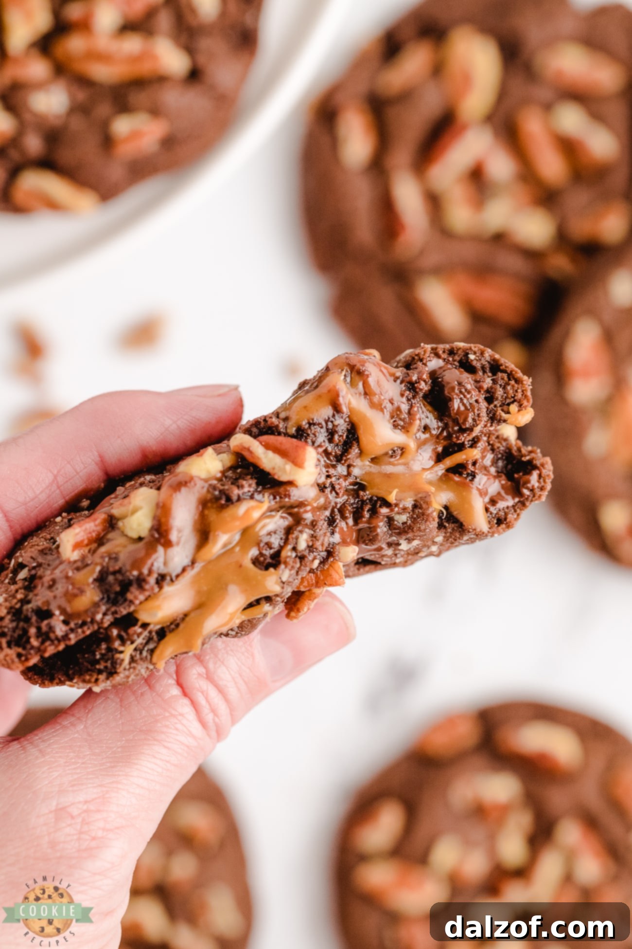 chocolate turtle cookies broken in half with caramel