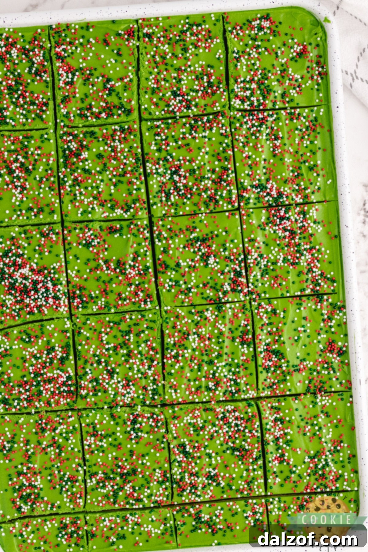 Pan of Christmas sugar cookie bars sliced into squares and ready to eat