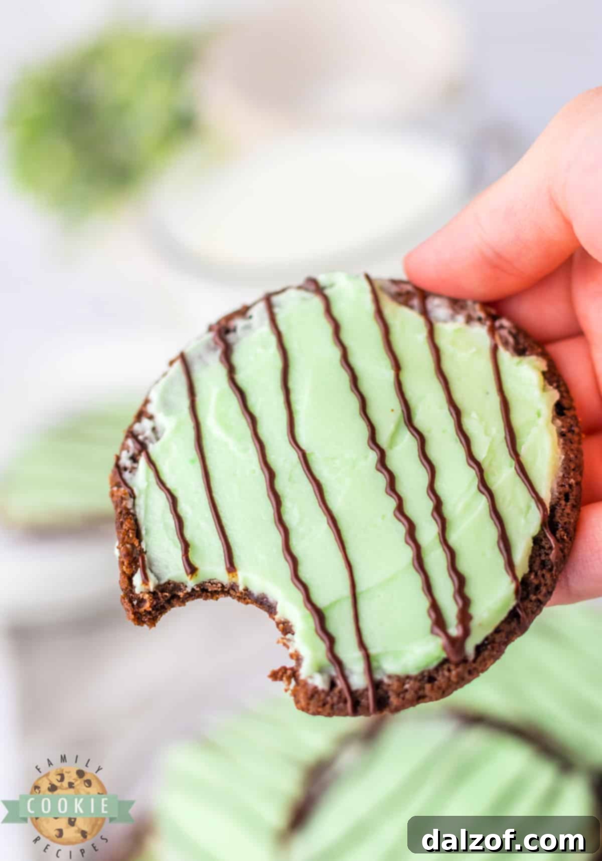 Close-up of a stack of Frosted Mint Chocolate Cookies, highlighting the rich chocolate base and smooth green mint frosting.