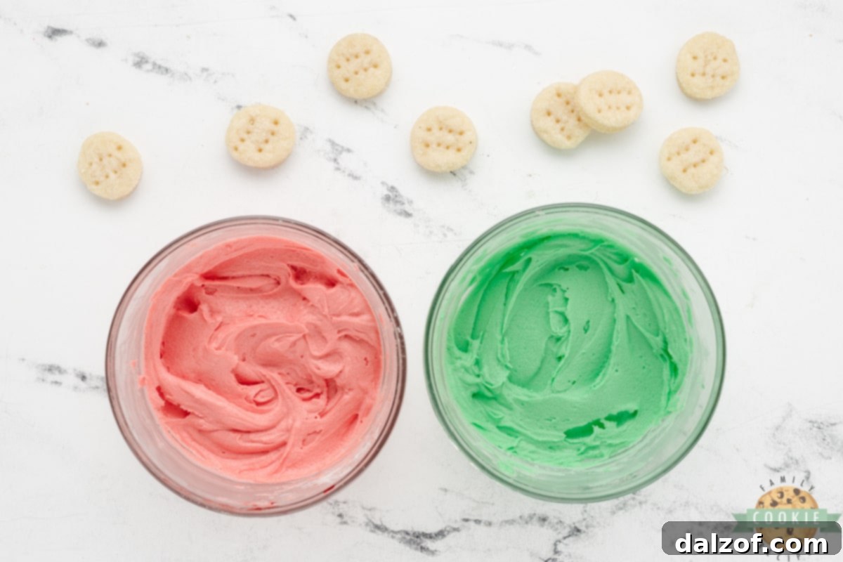 Red food coloring being mixed into a bowl of creamy frosting to achieve a festive hue.