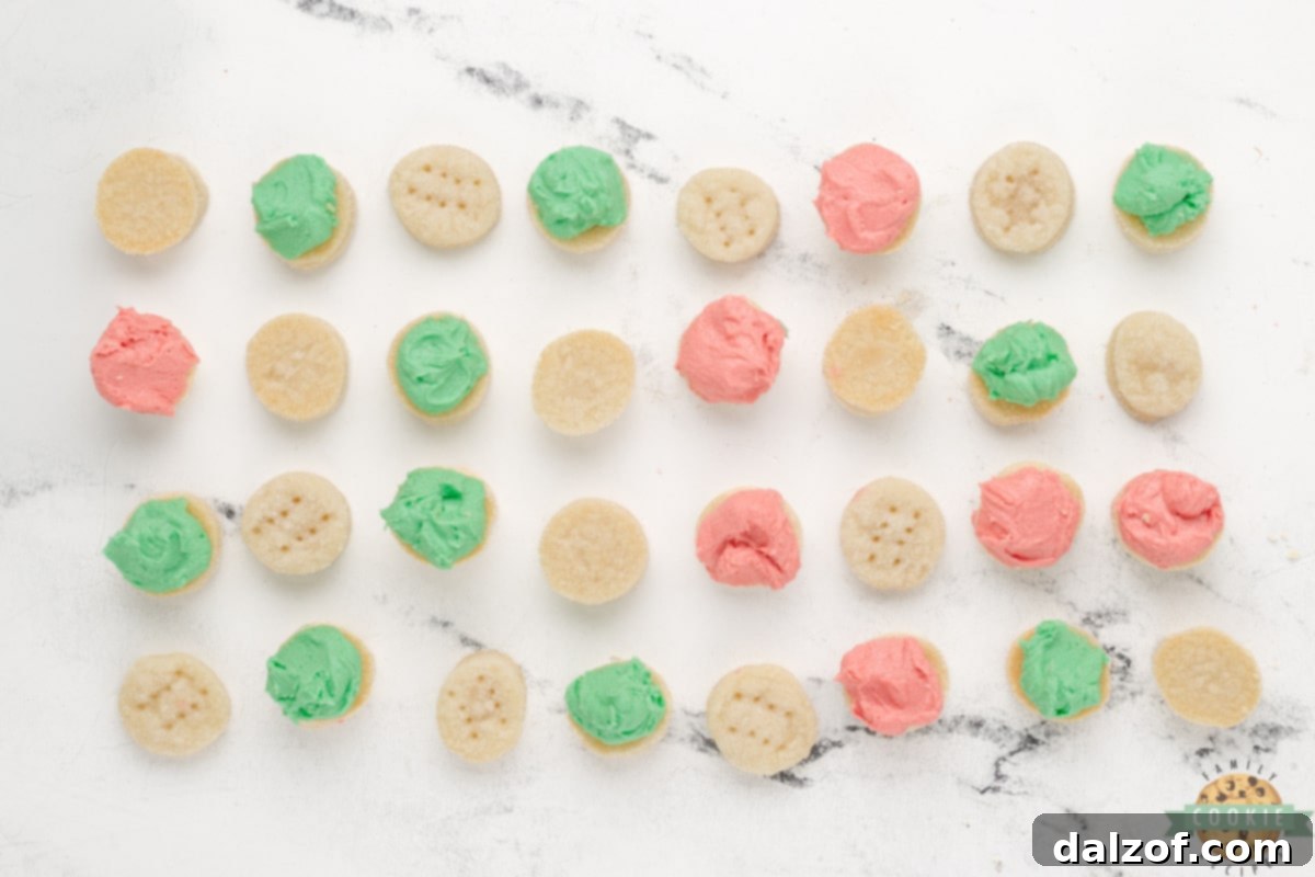 Assembly of Mini Christmas Sandwich Cookies, with frosting being spread on half of the cookies.