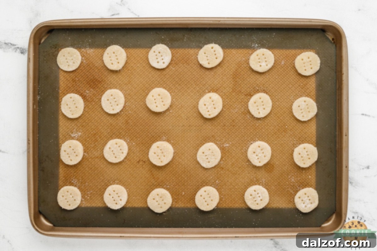 Baked tiny shortbread cookies cooling on a wire rack, perfectly golden.