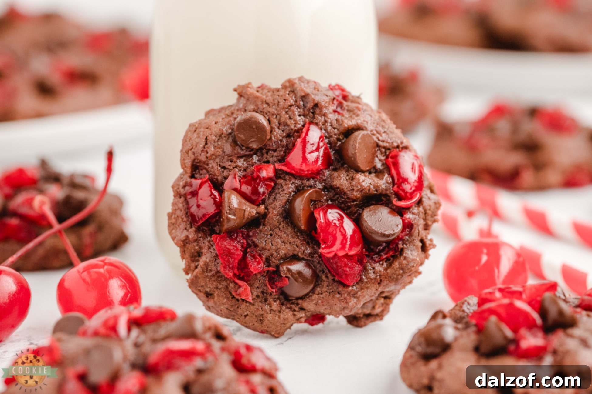 A single double chocolate cherry cookie with vibrant red cherry pieces, paired perfectly with a glass of milk, suggesting a delightful treat.