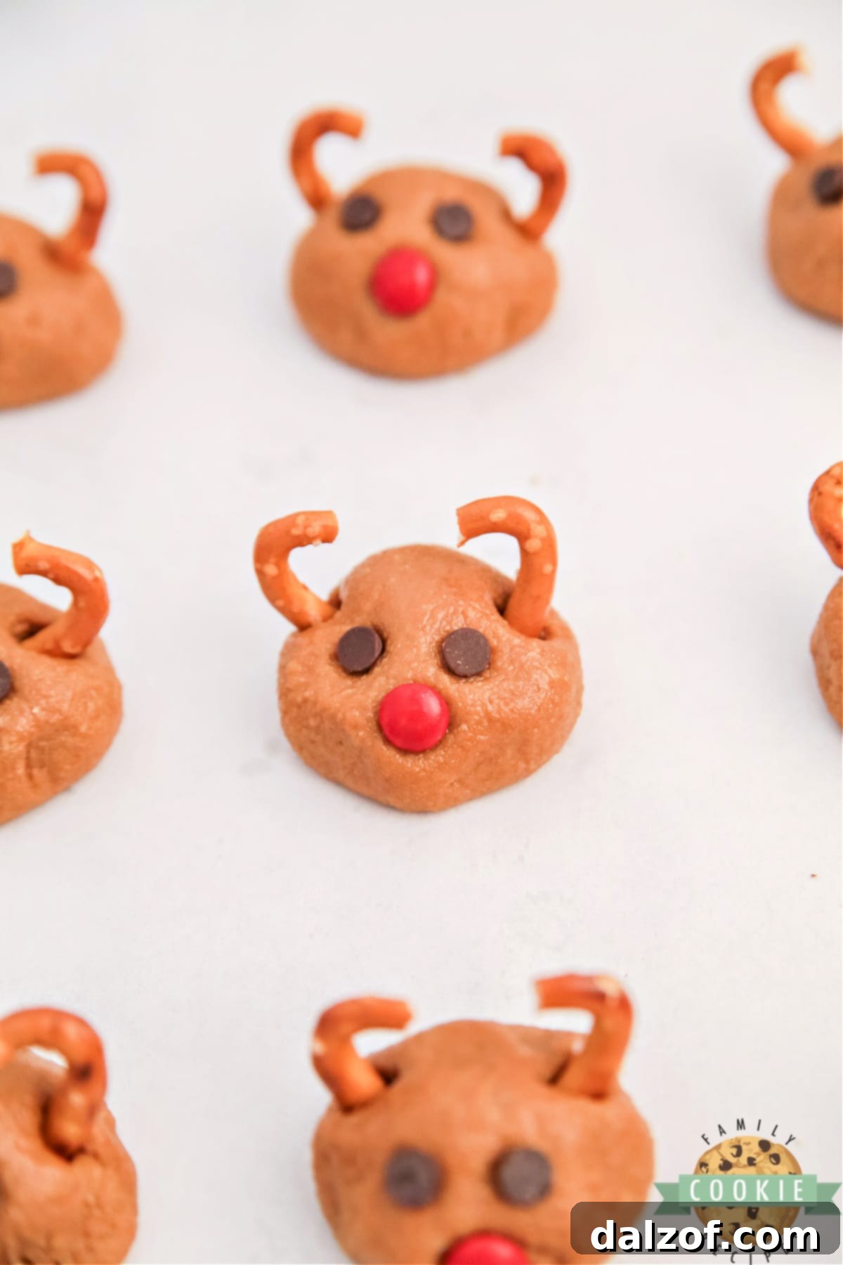 Rudolph's Red-Nosed Cookie Butter Delights 3 Close-up of adorable no-bake Rudolph Cookie Butter Balls with pretzel antlers and M&M noses, perfect for holiday gatherings.