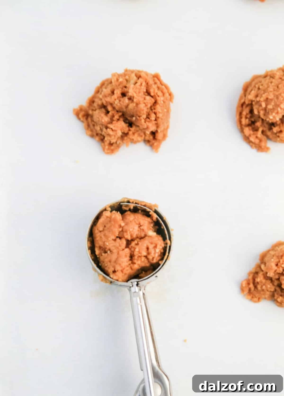 Rudolph's Red-Nosed Cookie Butter Delights 7 Scooping the cookie butter mixture onto a baking sheet, preparing for the chilling phase.