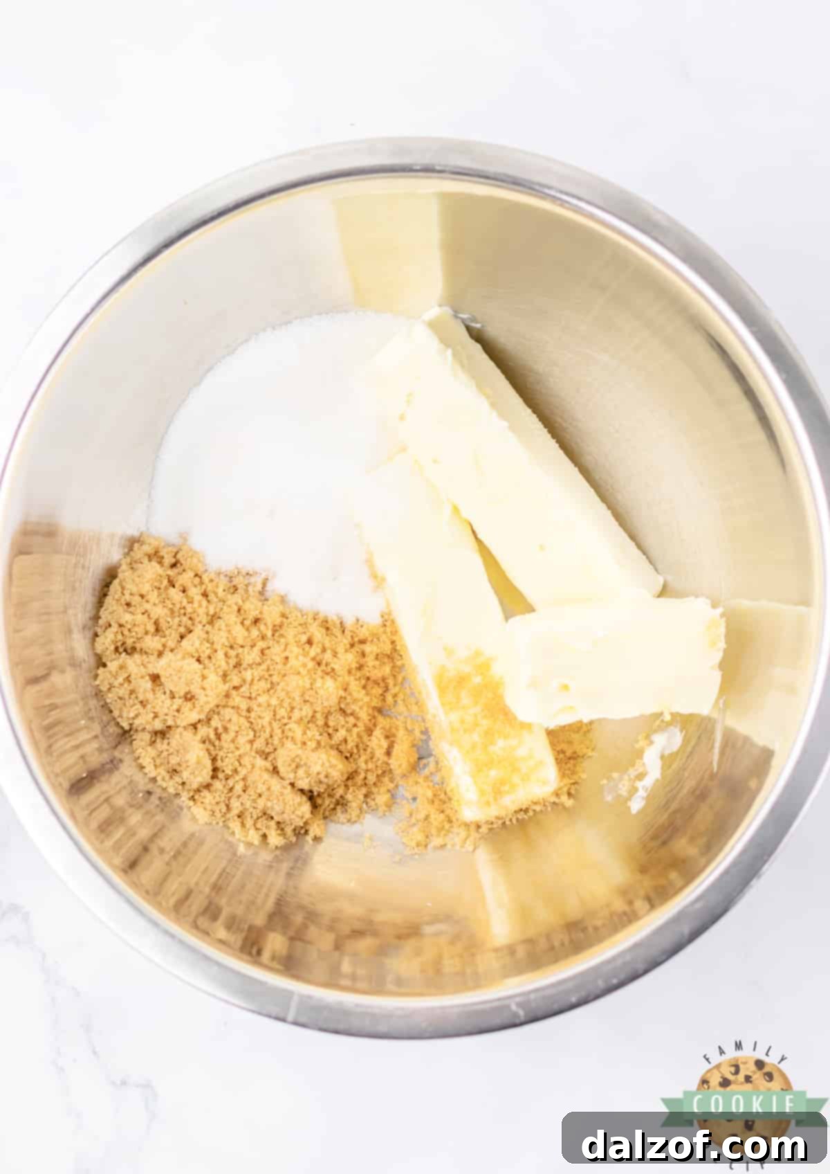 Creaming together softened butter, brown sugar, and granulated sugar in a large mixing bowl.