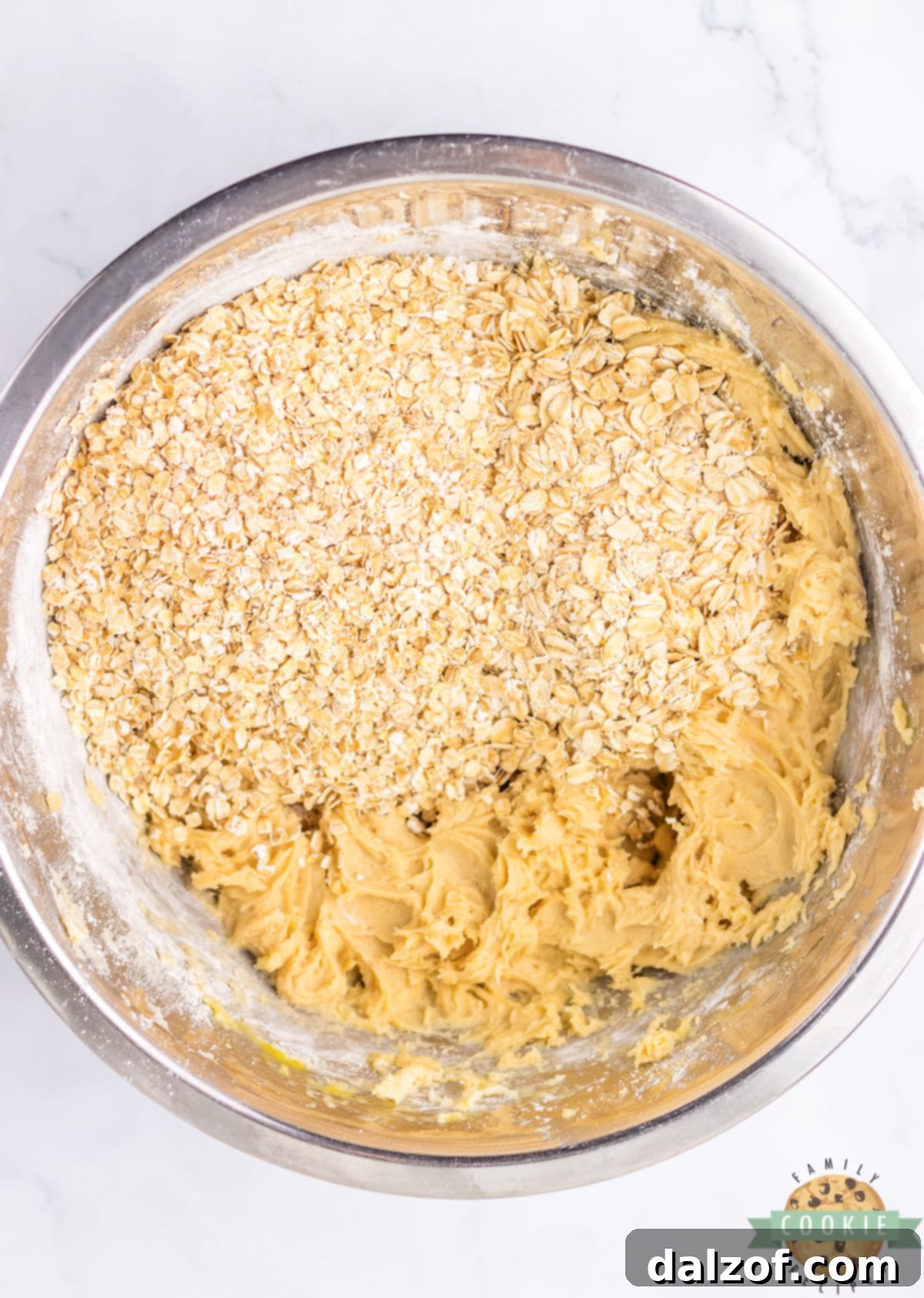 Folding in the quick oats and old-fashioned oats into the oatmeal cookie dough.