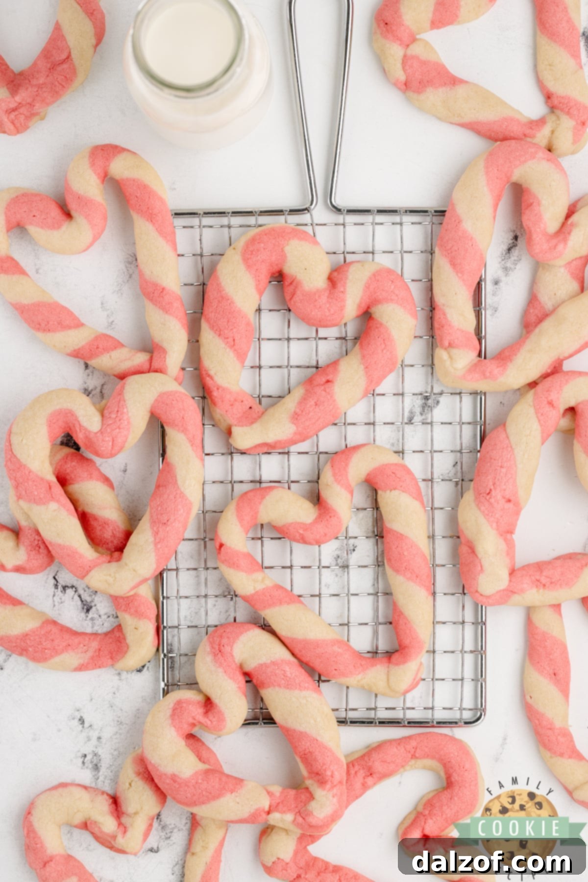 A close-up view of heart shaped cookies, showing the delicate pink and white braided design.