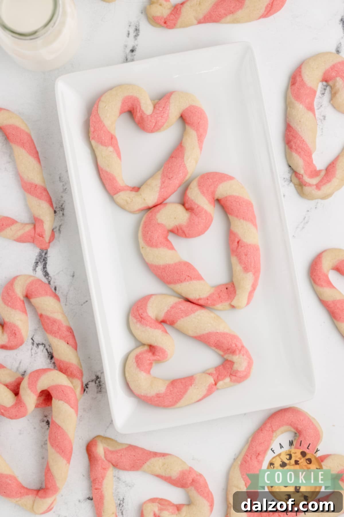 A tray of freshly baked Braided Sweetheart Cookies, showcasing their distinct pink and white striped heart patterns.