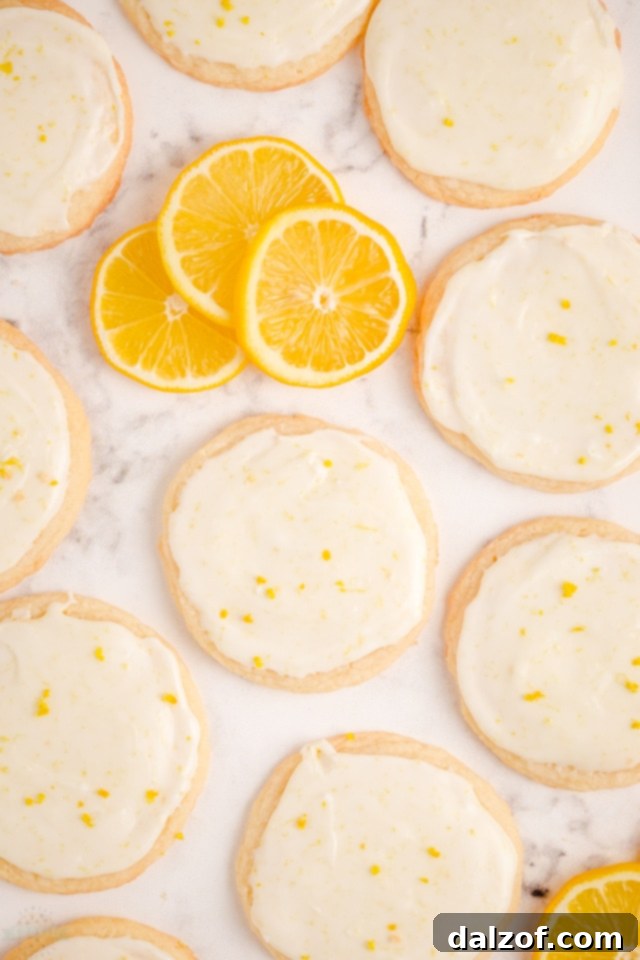 Freshly baked Lemon Meltaway Cookies cooling on a wire rack with lemon glaze