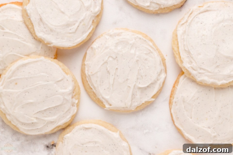 Side view of two Vanilla Meltaway Cookies on a plate, showing the glaze