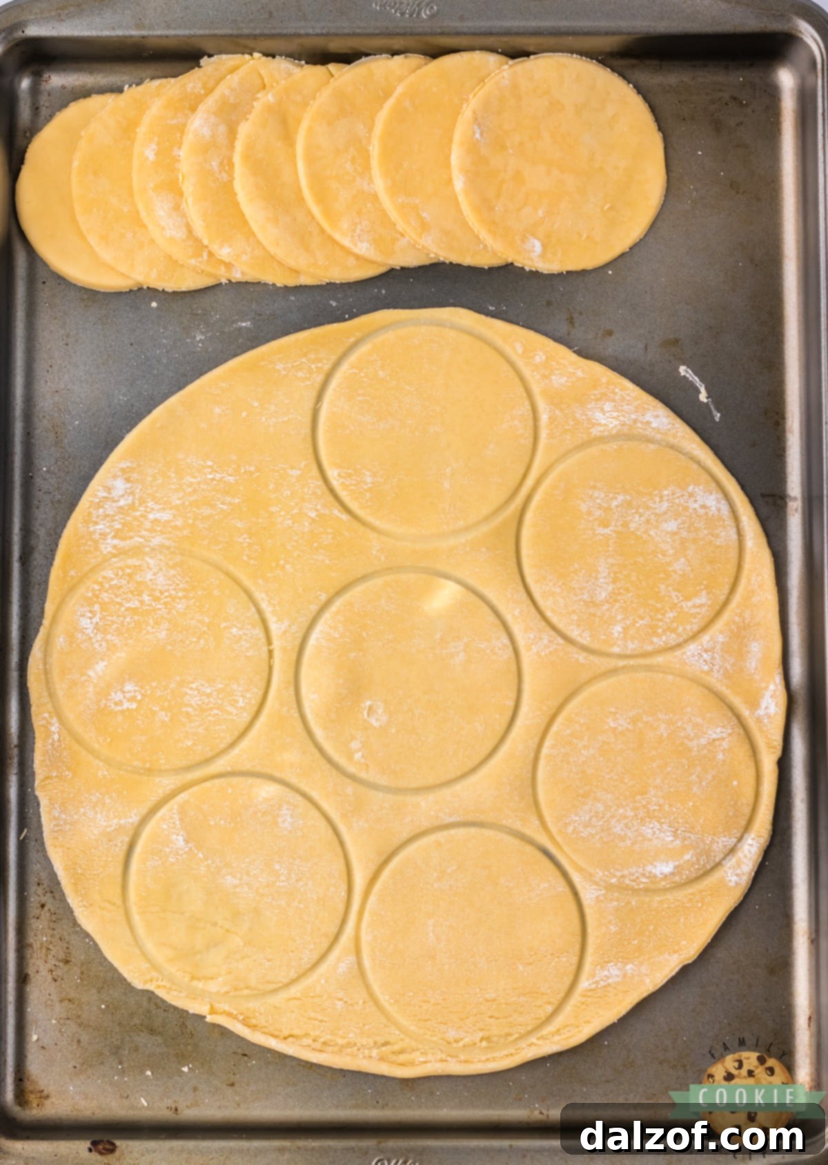 Close-up of a pie crust being cut into perfect circles using a cookie cutter, a foundational step for making Strawberry Pie Cookies.