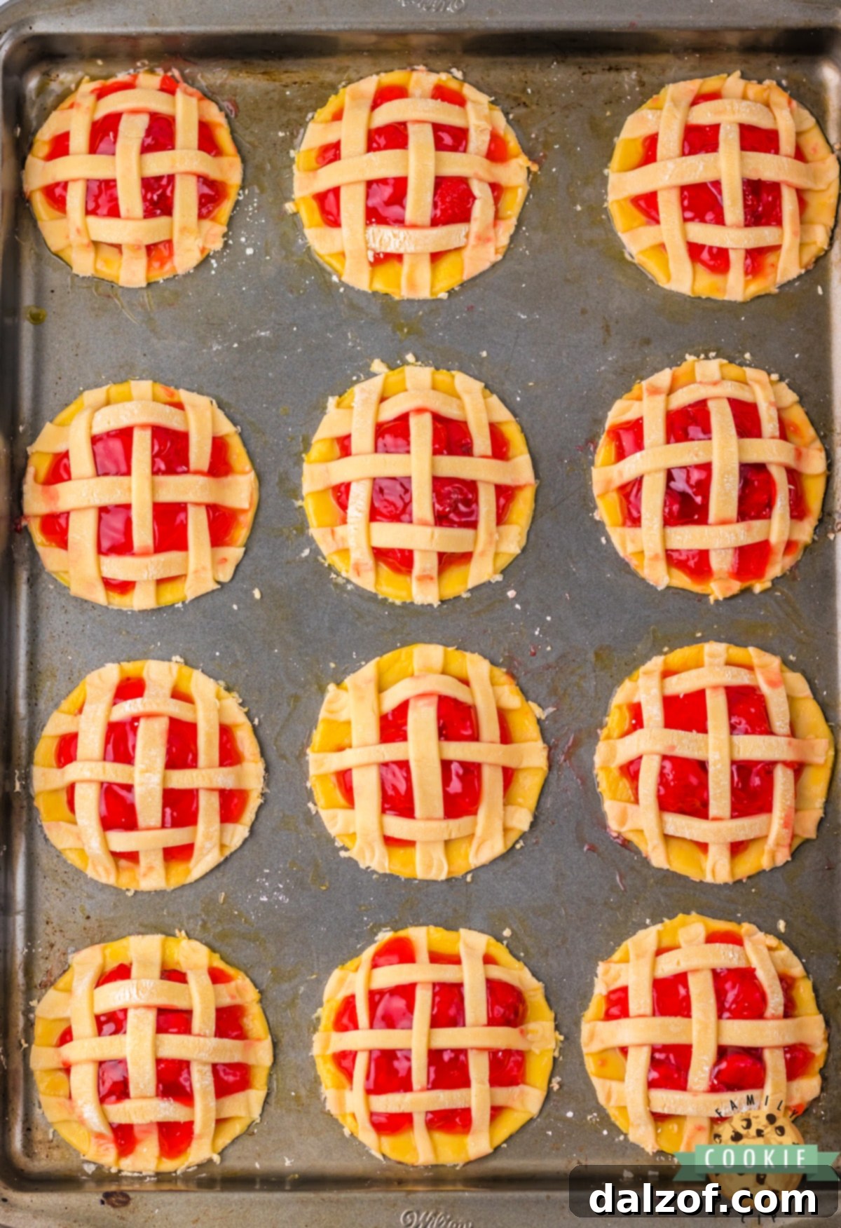 Delicately placed pie crust strips forming a classic lattice pattern over the strawberry pie filling, pressed onto egg-washed edges.