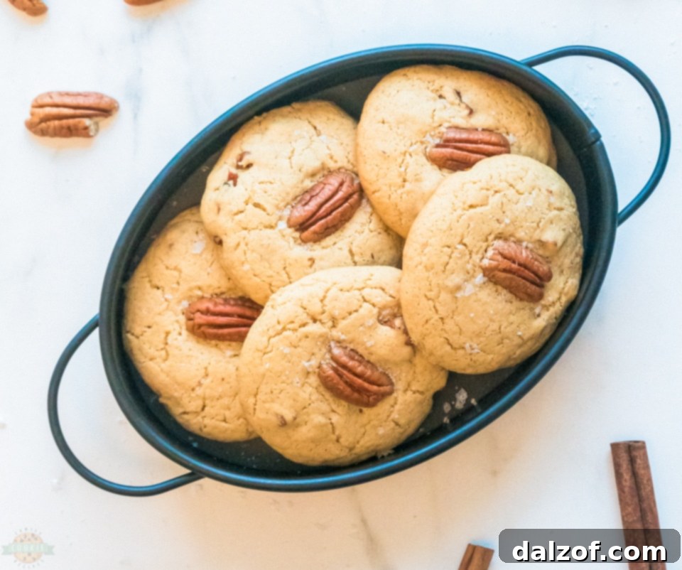 Various baking ingredients for Butter Pecan Cookies, including pecans, butter, sugar, and flour, arranged on a rustic surface