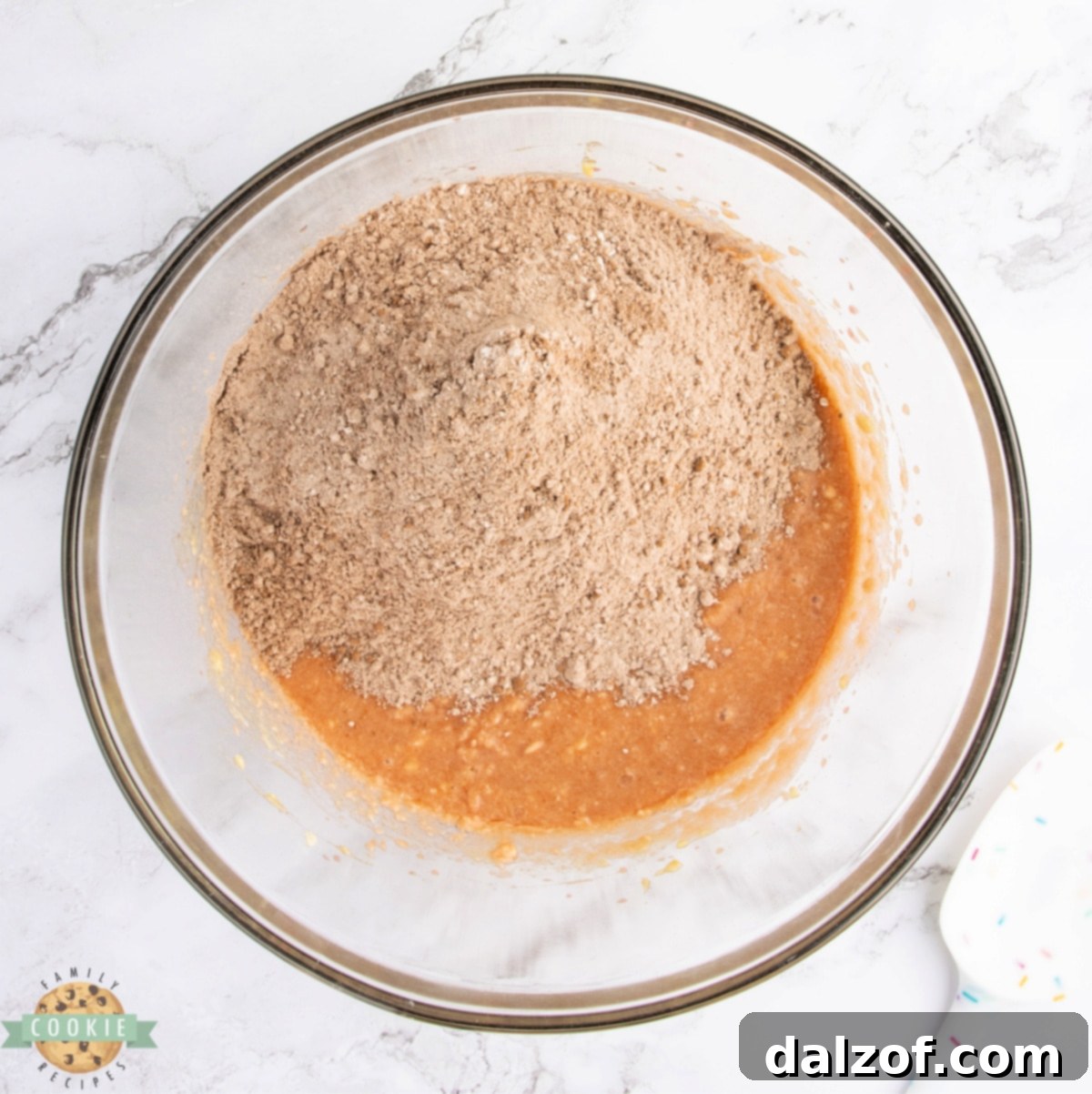 The process of mixing wet and dry ingredients together to form the cookie dough, ensuring a well-combined batter.