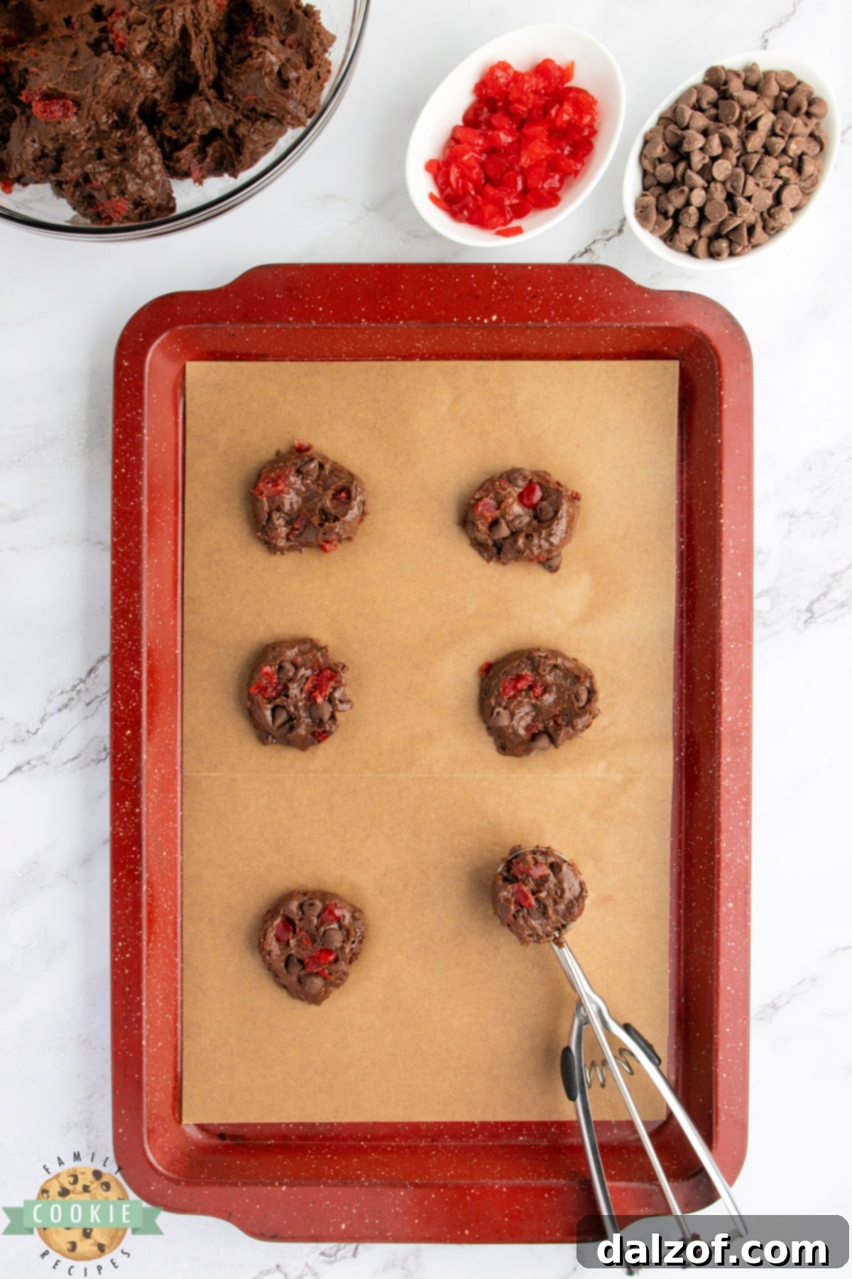 Scooping perfectly portioned cookie dough onto a prepared baking sheet, ready for refrigeration and baking.