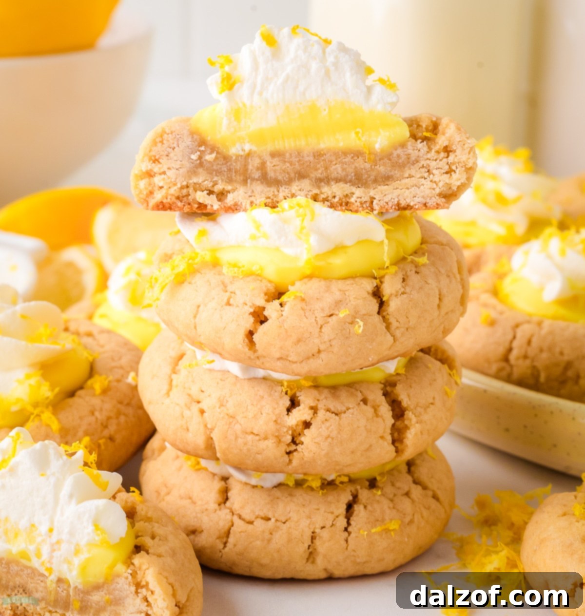 lemon pie cookies with one cut in half showing layers of lemon pudding and lemon cream, highlighting the perfect texture