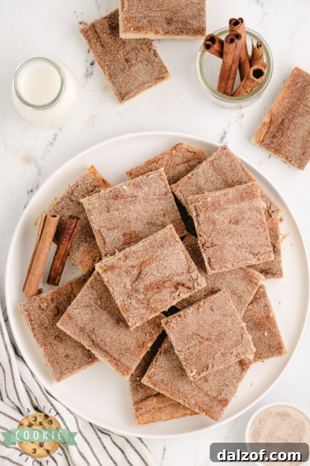 Close-up of baked Snickerdoodle Cookie Bars in a sheet pan, showcasing the golden-brown edges and generous cinnamon-sugar topping.