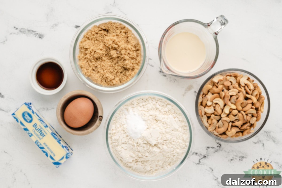 Arrangement of fresh ingredients for Cashew Cookies, including butter, brown sugar, egg, vanilla, cream, flour, baking soda, and cashews.