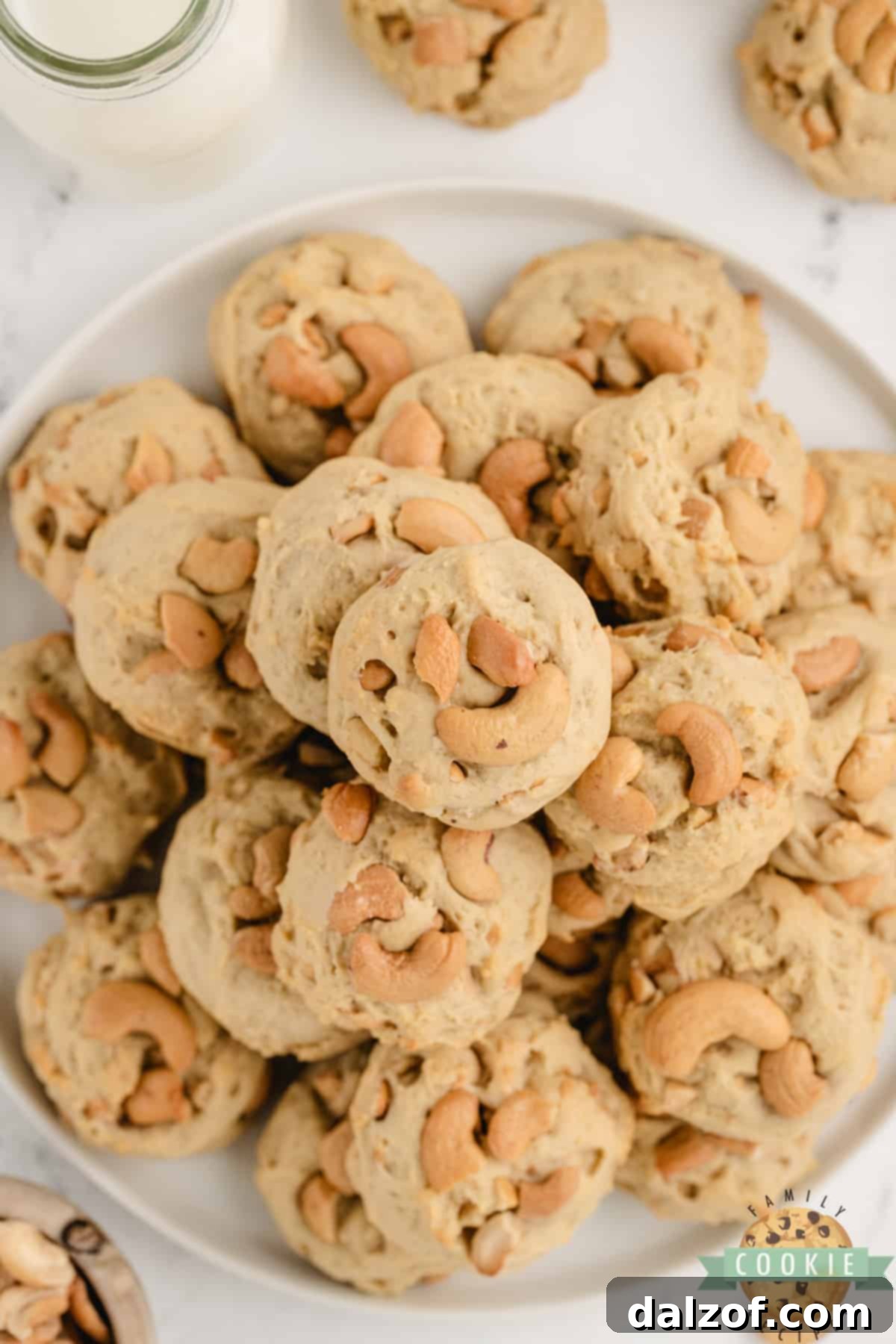 A plate of thick and chewy Cashew Cookies, showcasing their golden color and generous cashew pieces.