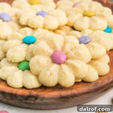 A vibrant display of Spring Spritz Cookies, shaped as flowers and adorned with M&M centers, ready to be enjoyed.