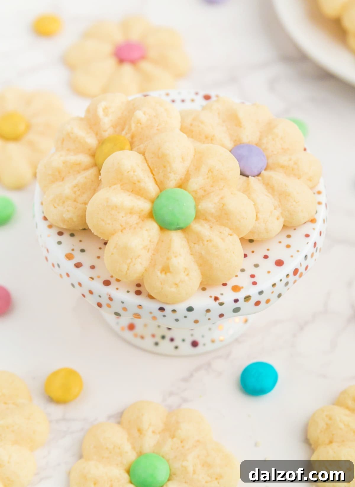 A vibrant selection of Spring Spritz Cookies, shaped as flowers with M&M centers, beautifully arranged for a spring dessert spread.