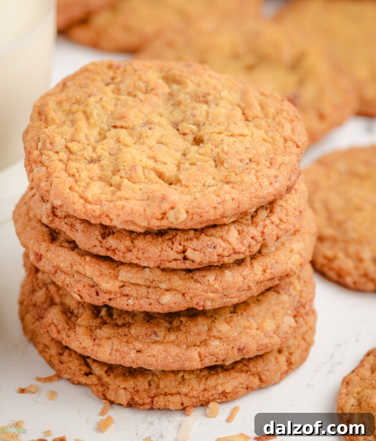 A perfectly stacked pile of freshly baked toasted coconut and walnut cookies, ready to be enjoyed.