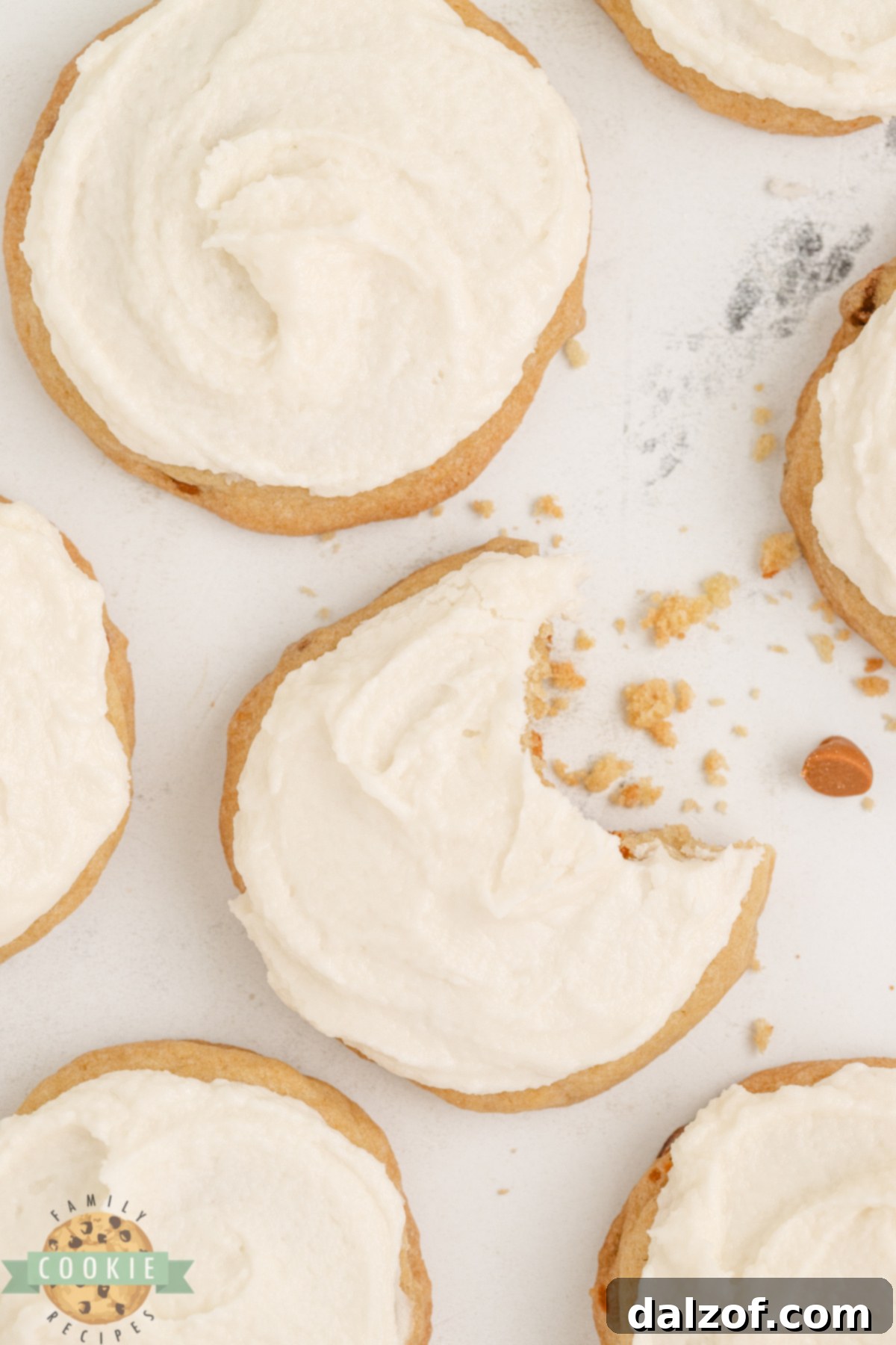 A close-up shot of a soft and chewy cinnamon cookie with a generous dollop of creamy buttercream frosting, resting on a white surface, ready to be enjoyed.