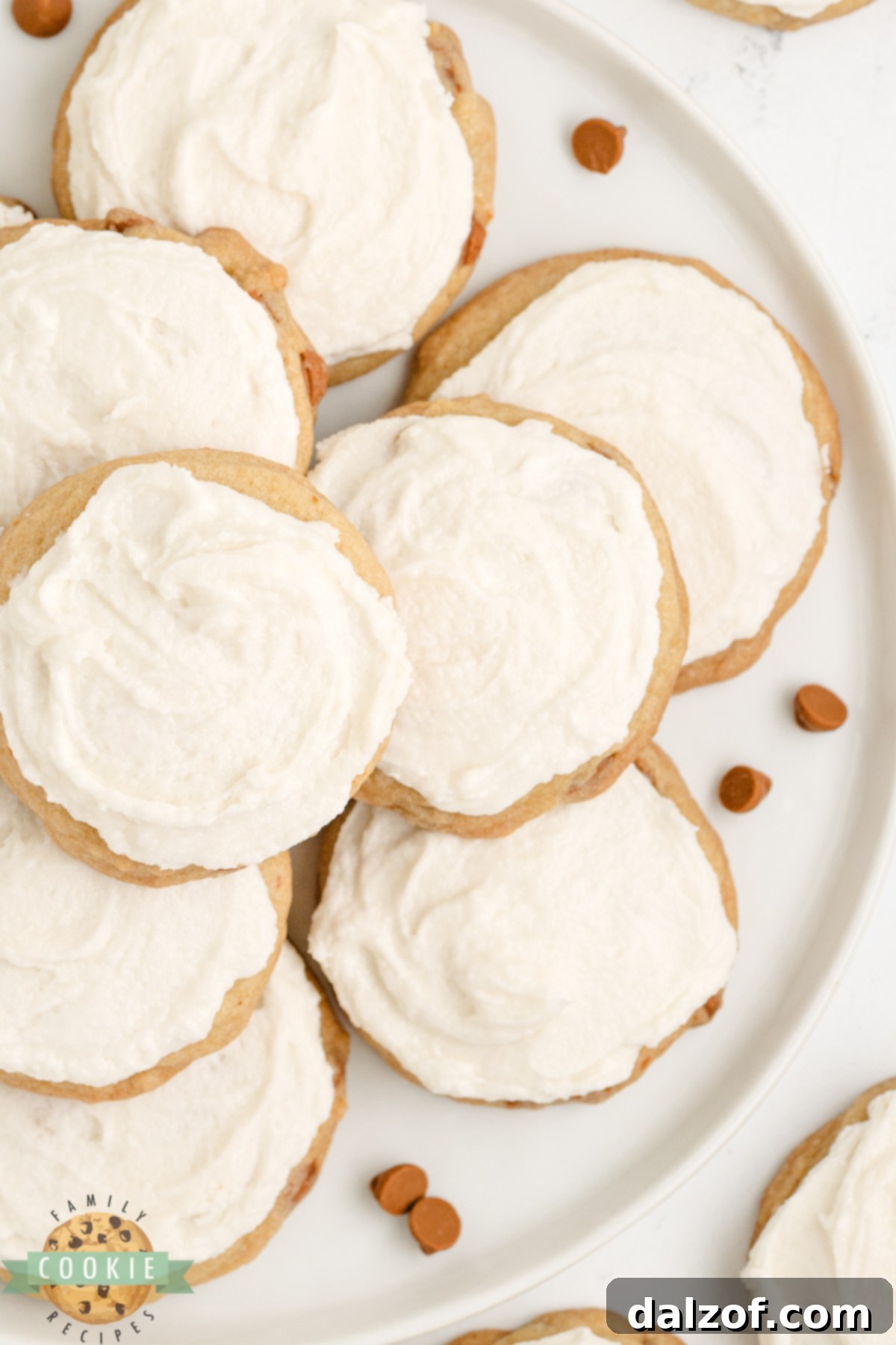 Close-up of soft and chewy cinnamon cookies, featuring golden brown edges, loaded with cinnamon chips and topped with a simple, smooth vanilla buttercream frosting.