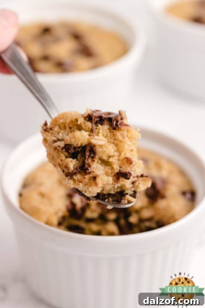 A warm, soft Microwave Oatmeal Chocolate Chip Cookie in a mug, ready to eat.