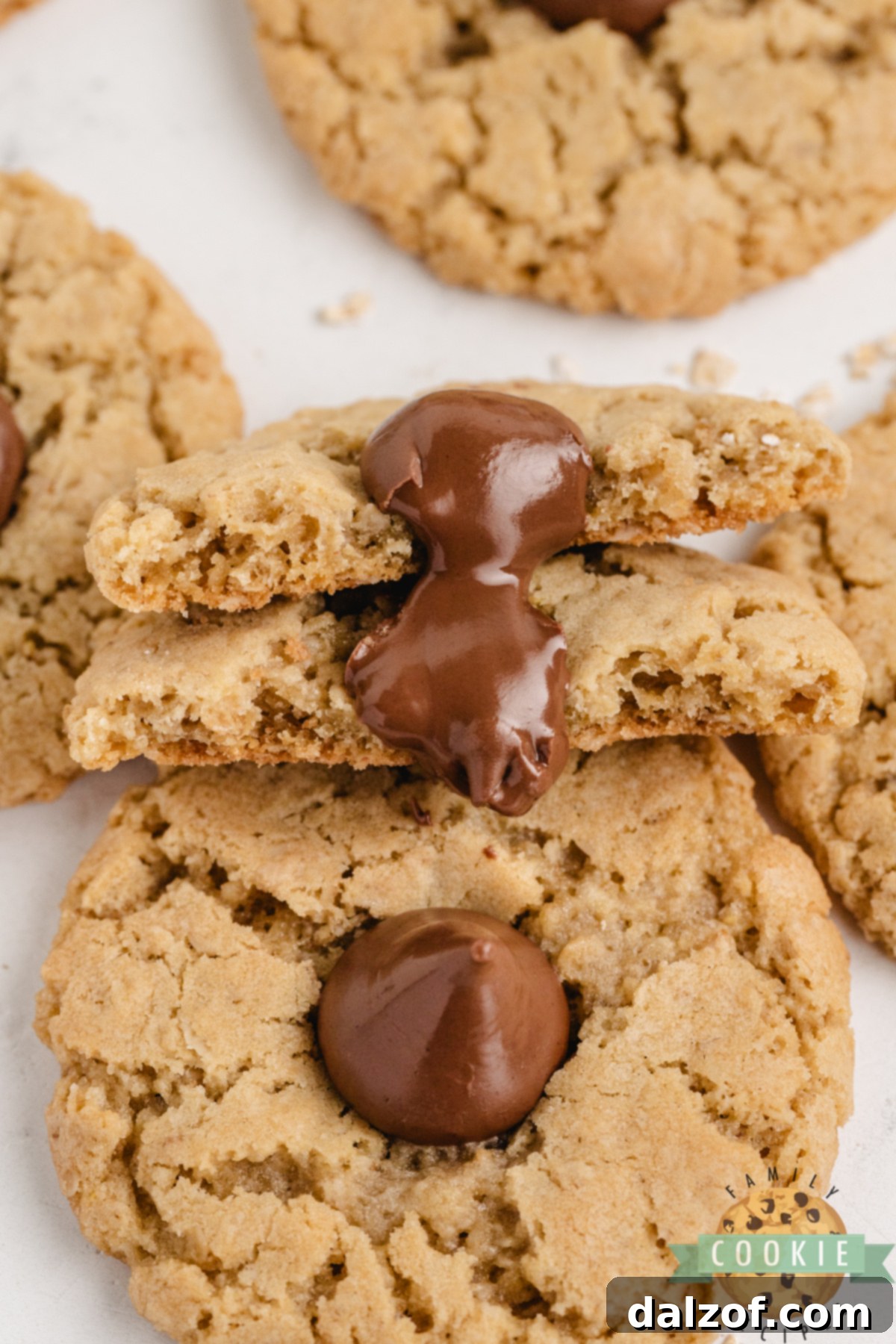 A stack of golden brown Oatmeal Kiss Cookies with shiny chocolate Kisses, ready to be enjoyed. Highlighted for their soft, chewy appeal and delicious flavor.