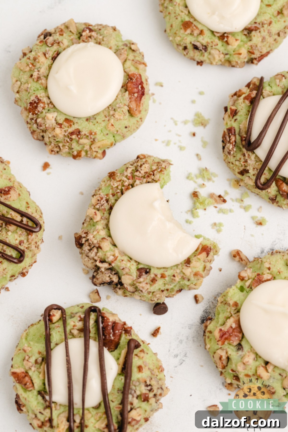 Soft pistachio thumbprint cookies with chocolate chips, pecan coating, and vanilla filling—easy to make and absolutely delicious!