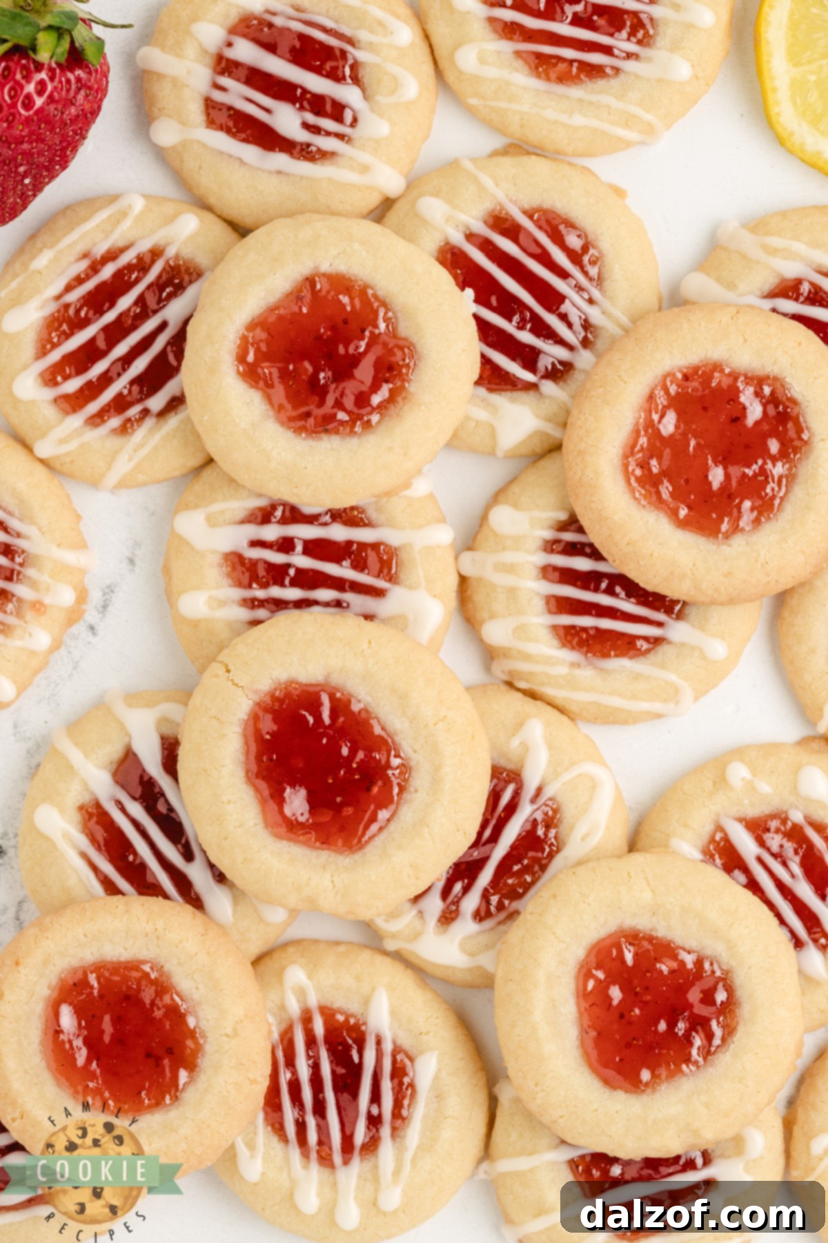 Strawberry Lemon Thumbprint Cookies are buttery, citrusy, and sweet—filled with jam and topped with a tangy lemon glaze!