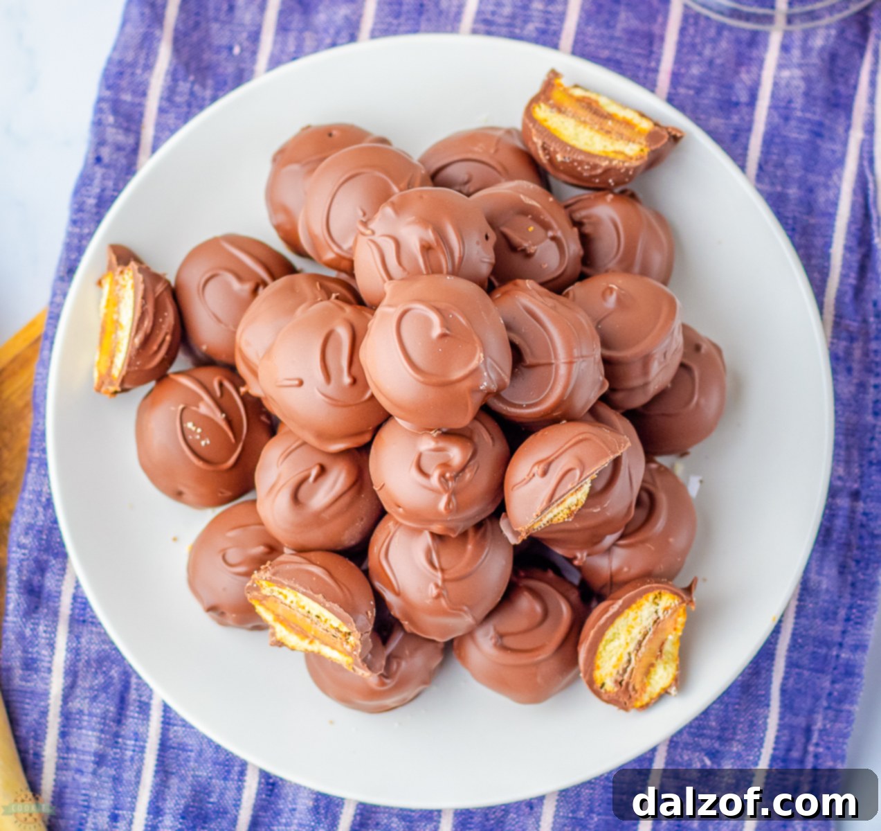 Easy 3-ingredient Twix Cookie Bites on a pristine white plate, showcasing their delightful chocolate coating and perfect bite-sized form.