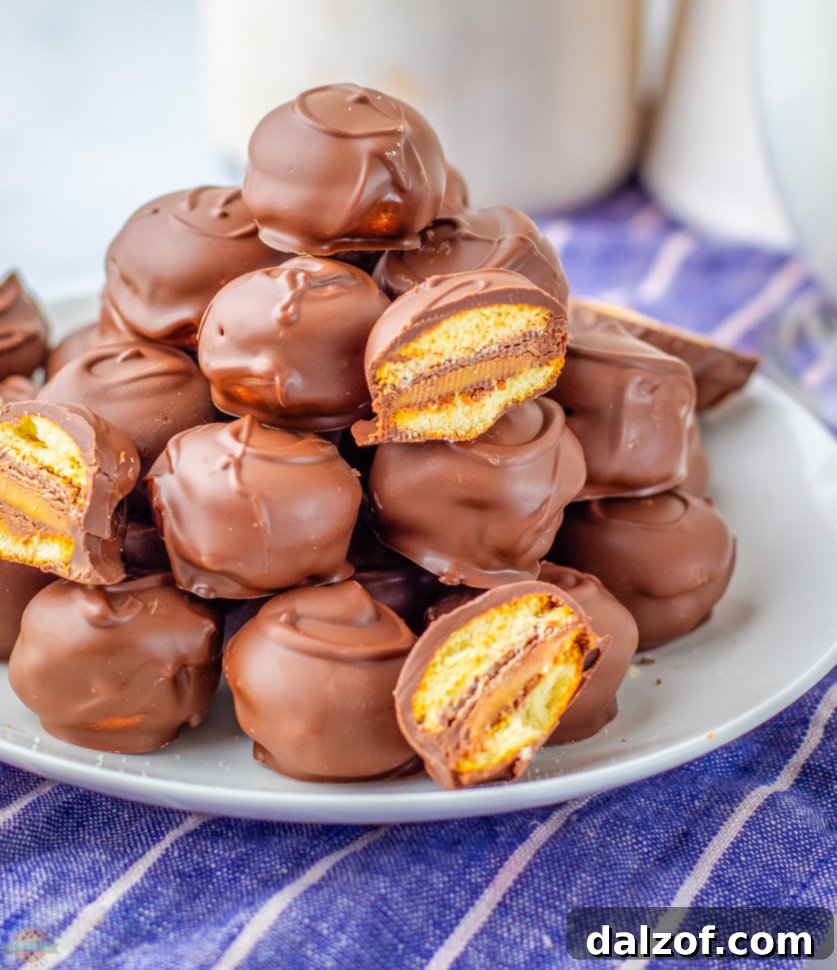 A plate full of delicious Twix Cookie Bites, perfectly coated in chocolate, ready to be enjoyed.