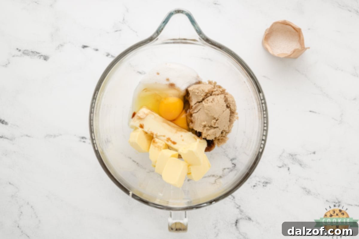 Mixing butter, shortening, sugars, eggs, and vanilla for cookie dough.
