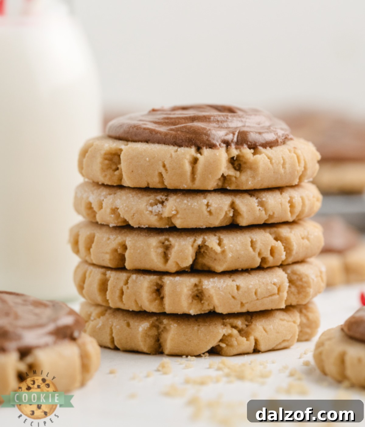Thick and soft peanut butter cookies generously topped with rich chocolate frosting, ready to be enjoyed.