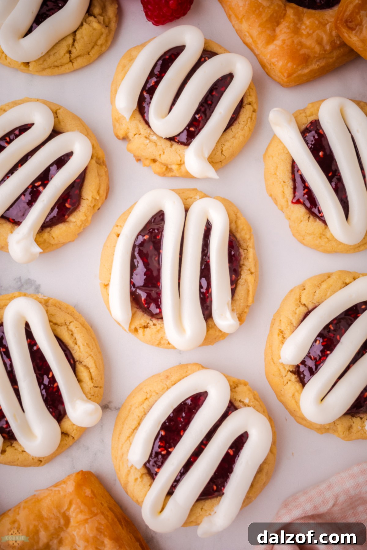 A close-up shot of Raspberry Danish Cookies on a baking tray, showcasing their perfect texture and vibrant toppings