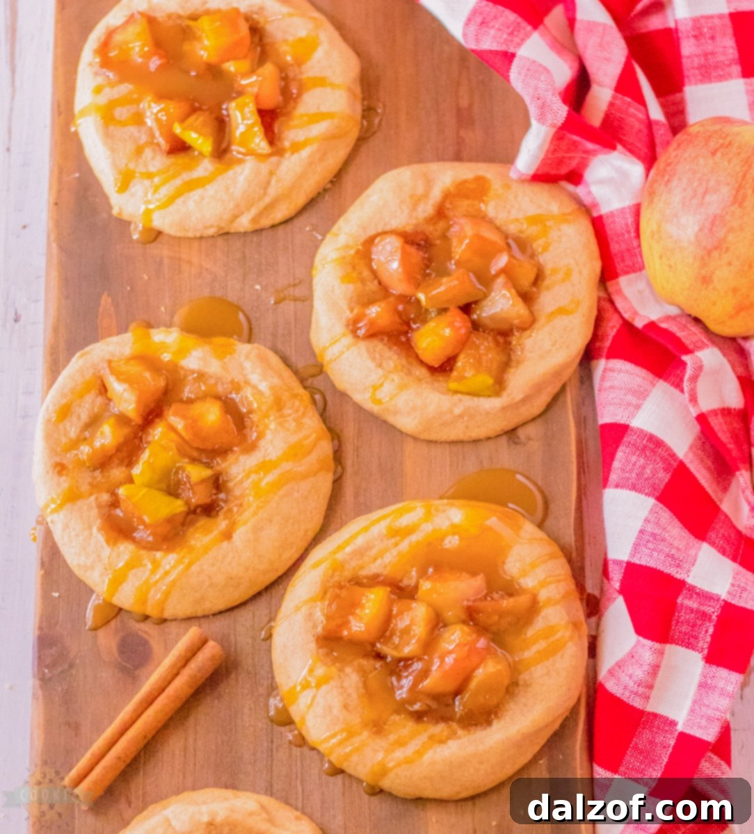 Close-up of a single apple pie cookie with golden crust and visible apple filling