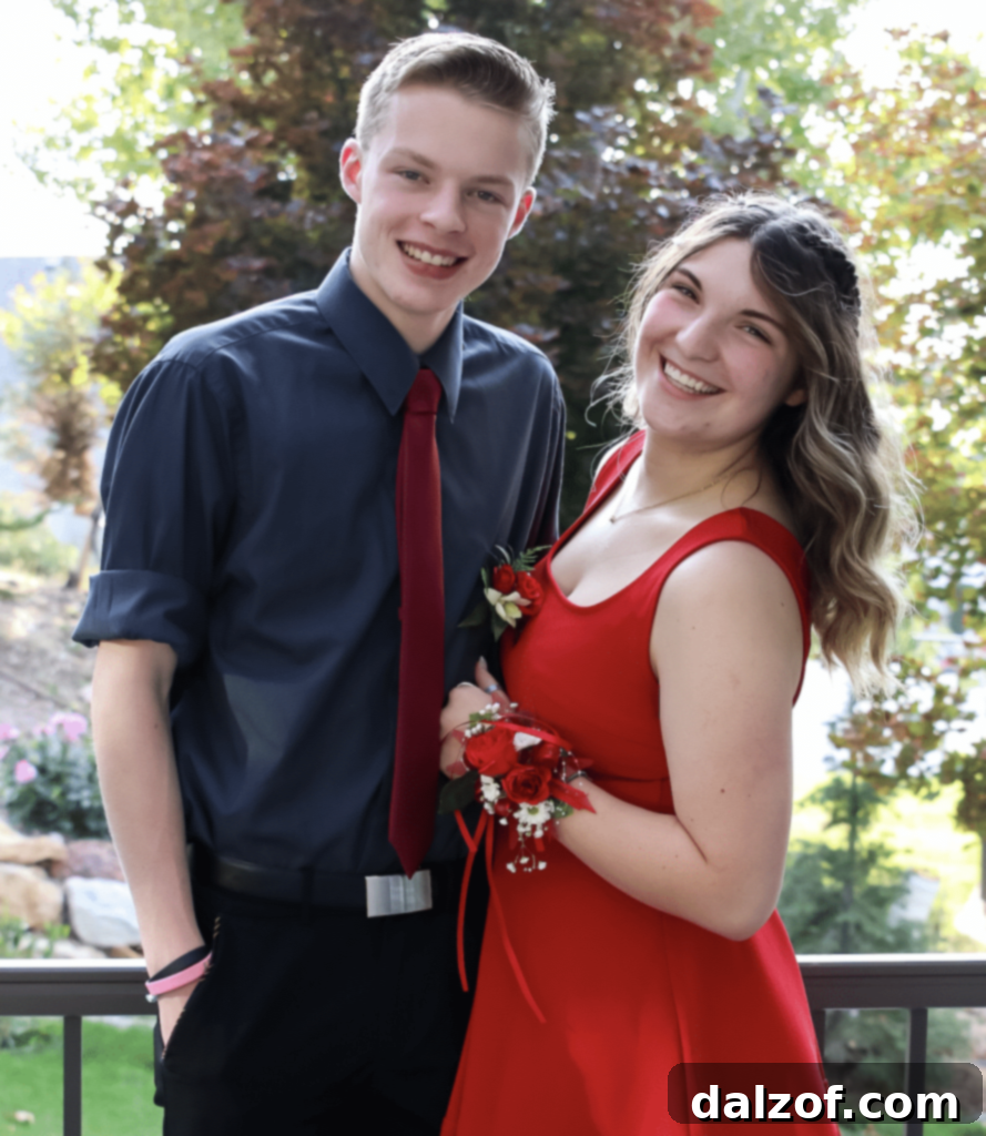 Two happy teenagers dressed for Homecoming, smiling for a photo