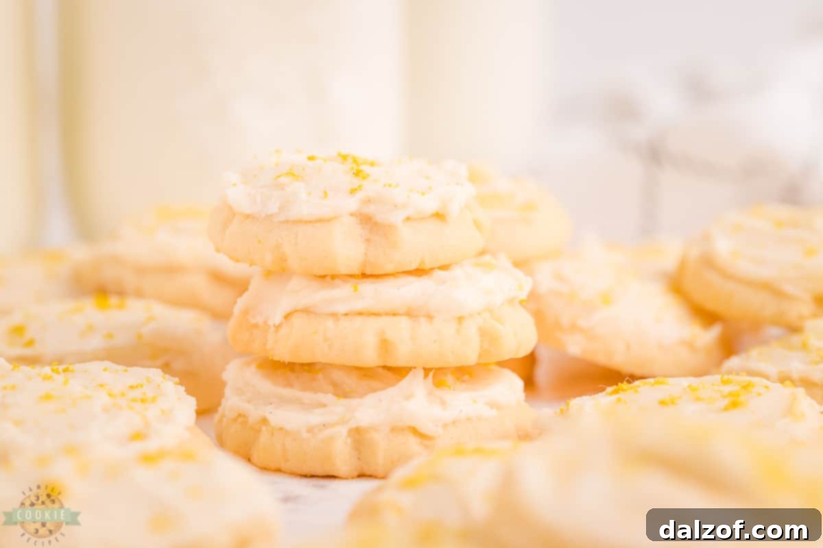Stack of mini frosted sugar cookies with parchment paper in between for storage
