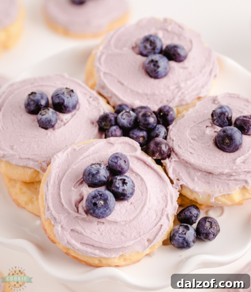 Freshly baked blueberry sugar cookies with a vibrant purple blueberry buttercream frosting, perfect for any occasion.