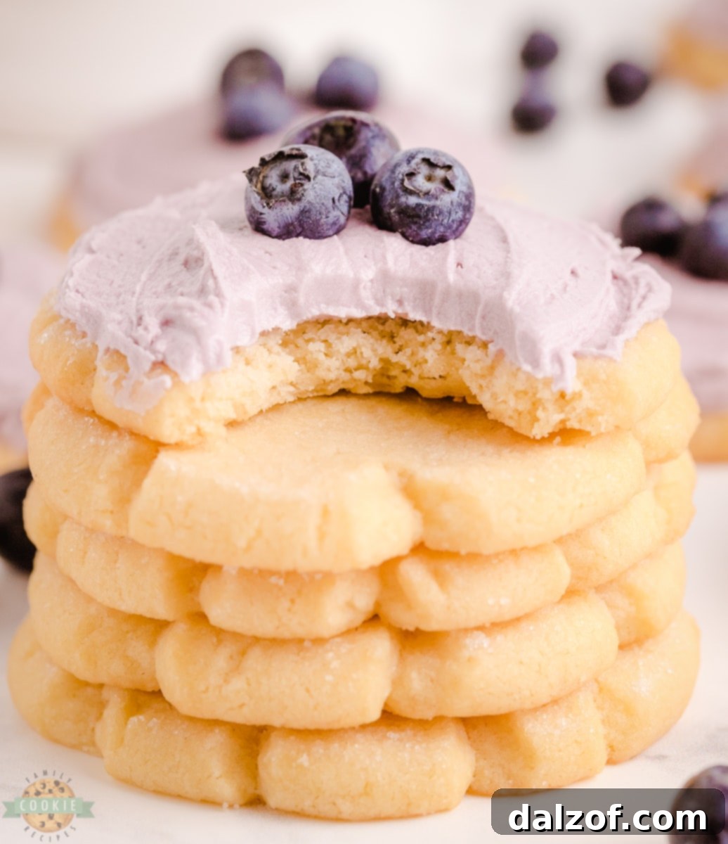 Close-up of a blueberry sugar cookie stack, showing the thick, soft texture and generous frosting.