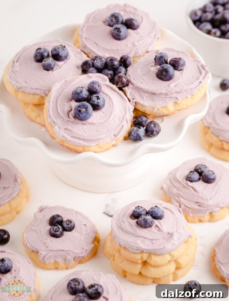 A plate of perfectly frosted blueberry sugar cookies ready to be served.