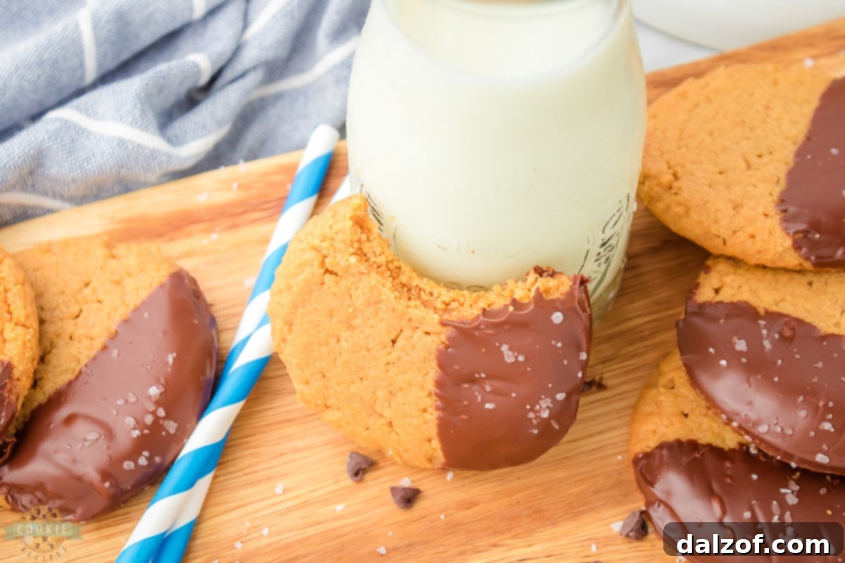 Close-up of a stack of homemade gluten-free peanut butter cookies, half-dipped in chocolate.