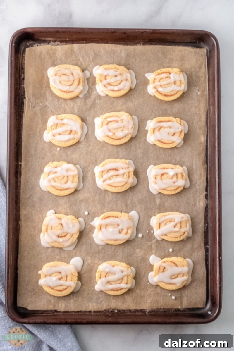 Cinnamon roll cookie dough being rolled into a tight log, demonstrating the technique for achieving the perfect swirl.