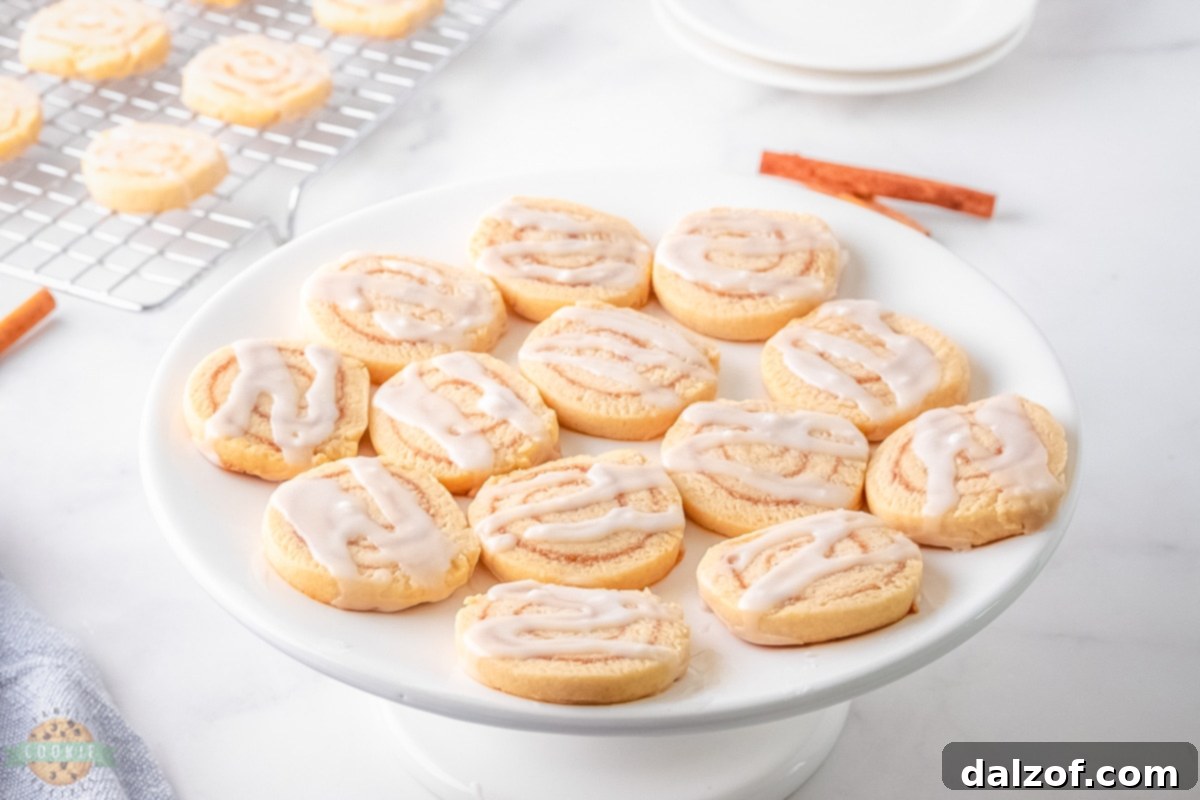A bowl of dough for cinnamon roll cookies, alongside a rolling pin and parchment paper, ready for preparation.