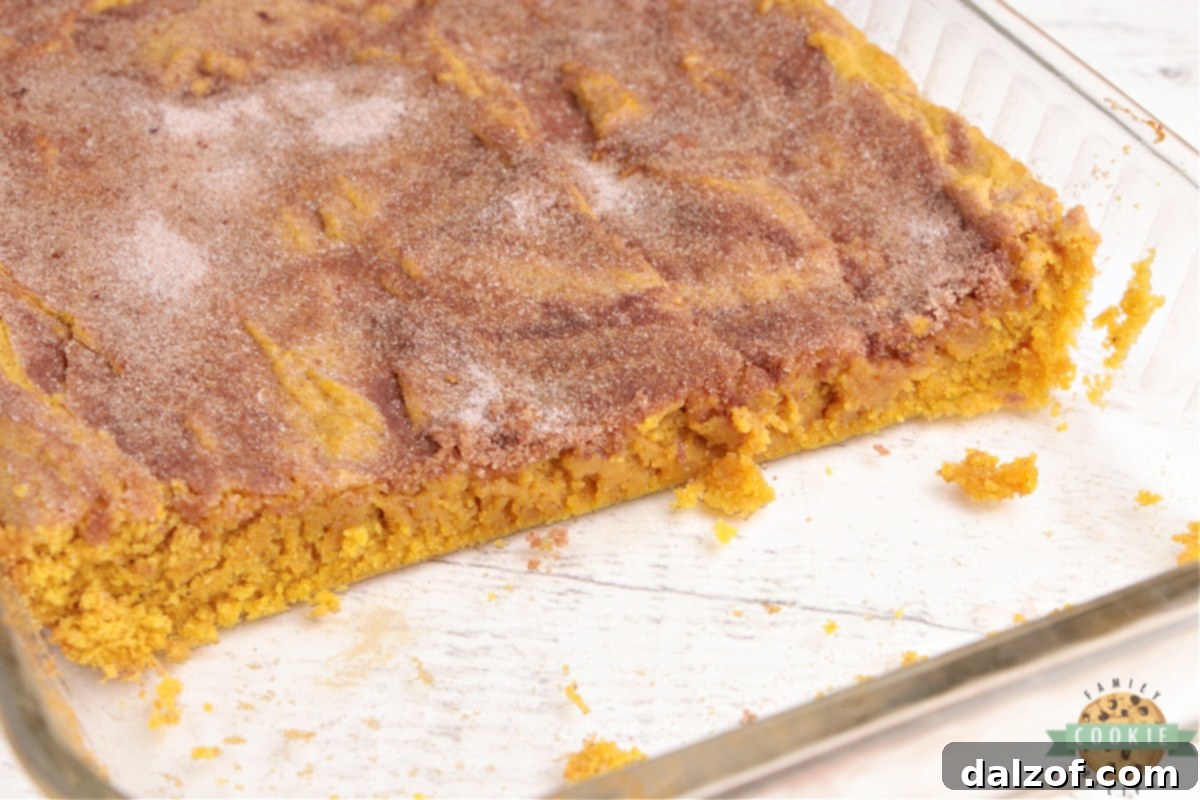 A pan of freshly baked pumpkin snickerdoodle cookie bars, generously topped with cinnamon sugar.